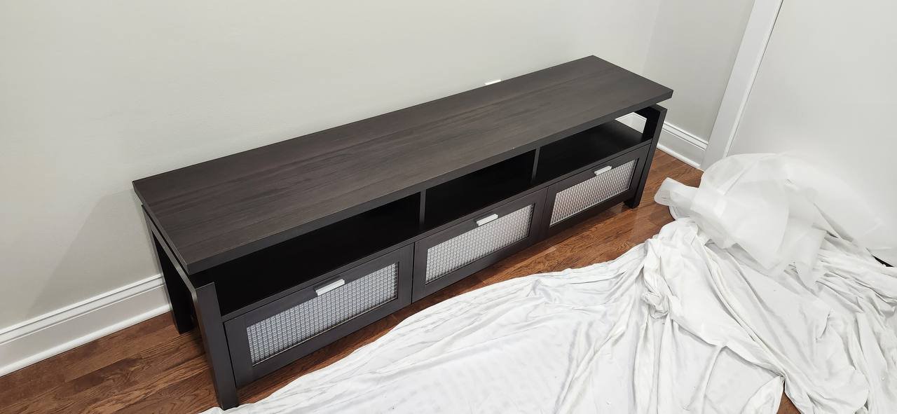 Completed dark-finish TV console with three textured cabinet doors and open shelves in Center City Philadelphia