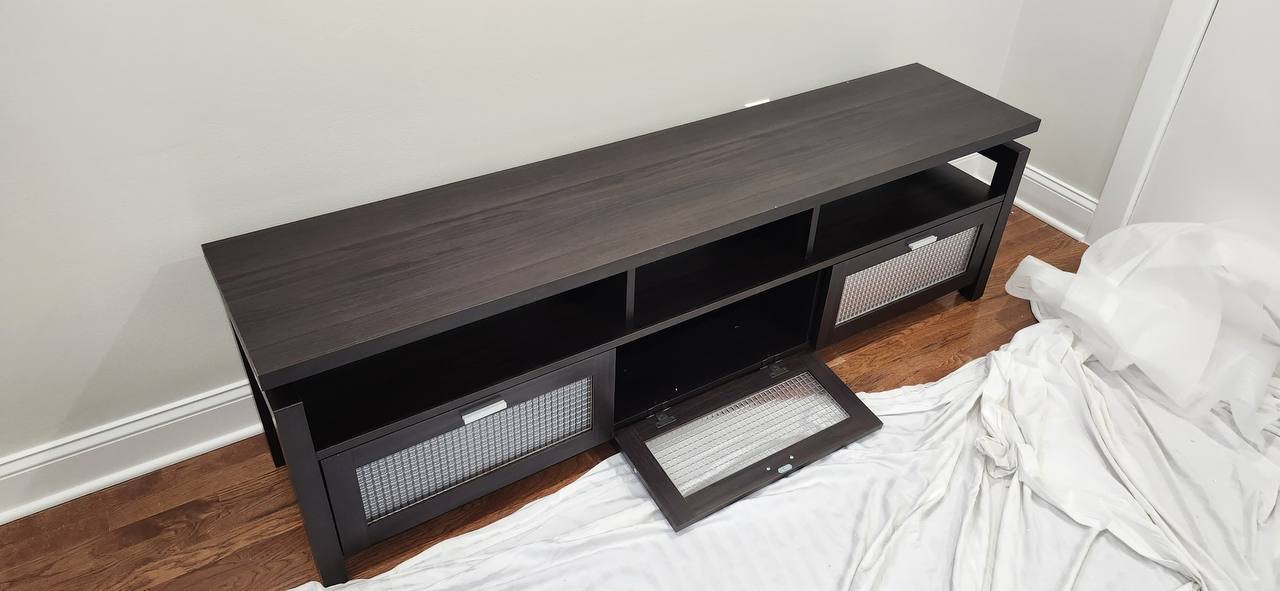 Dark-finish TV console with its center drop-down door open and two side doors closed